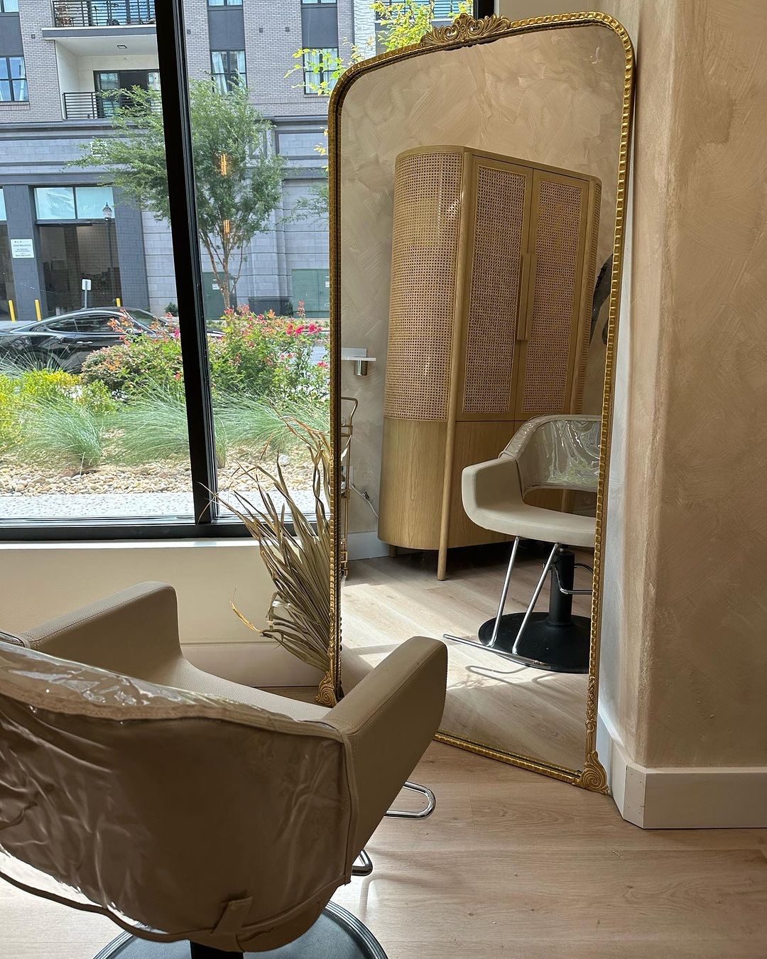 Inside a MINT salon suite with gold mirror and garden window